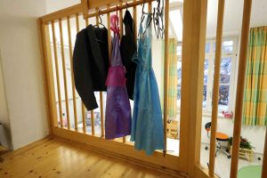 Igelgruppe Kleidungstücke zum Verkleiden hängen an Gitter Empore