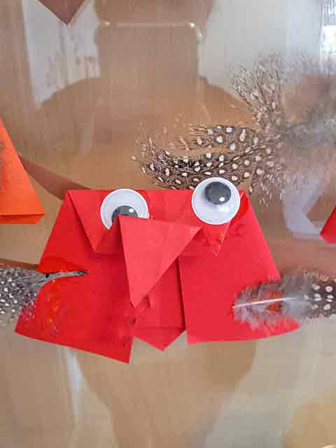 Eine aus rotem Papier gefaltete Eule eines Gruppenkinds