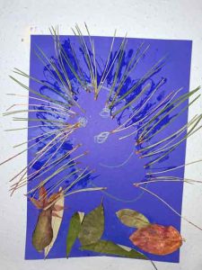 Igelbild mit Kiefernadeln und Blättern auf farbigem Papier gestaltet